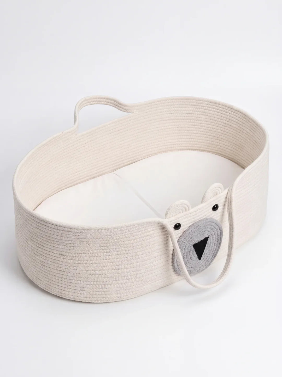 Panier à langer ourson kaki posé sur commode en chêne dans une chambre bébé