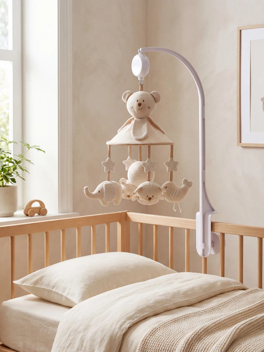 Vue d'ensemble d'un mobile musical beige installé sur un lit à barreaux dans une chambre d'enfant.