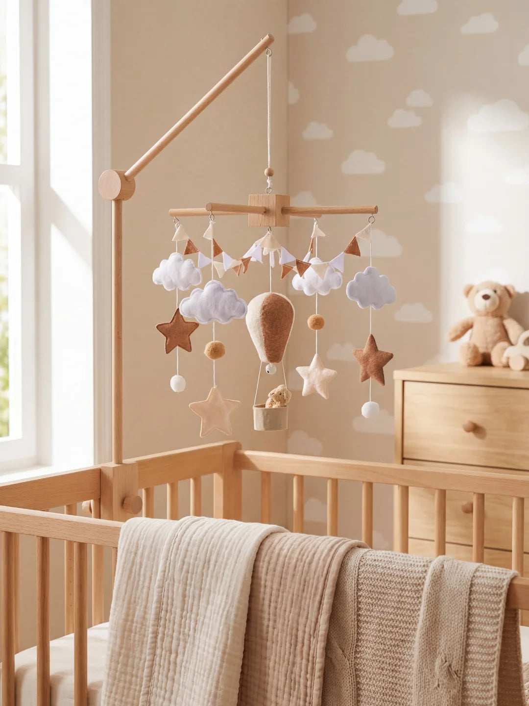 Bras de support en bois naturel fixé au lit bébé pour mobile montgolfière.