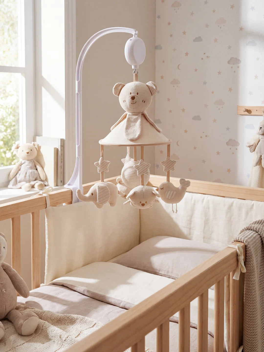 Mobile motorisé avec bras blanc incluant des peluches d'éléphant, d'ours et d'oiseau en tissu rayé.