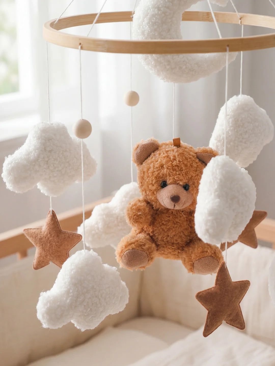 Détails des suspensions : ours brun, étoiles et nuages moutonneux pour l'éveil de bébé.