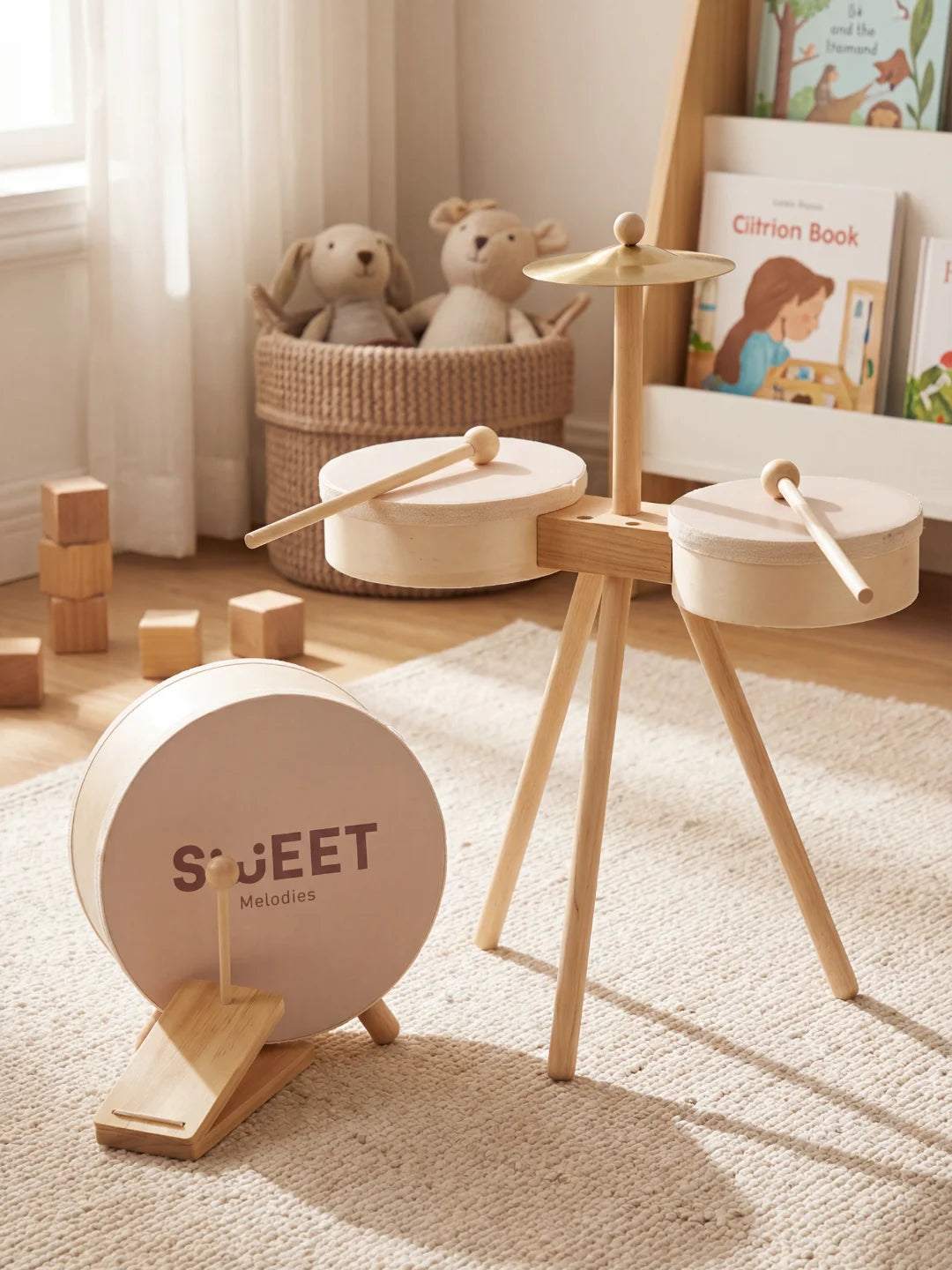 Batterie complète pour enfant en bois naturel avec deux tambours, une cymbale et des baguettes dans un décor de chambre épuré.