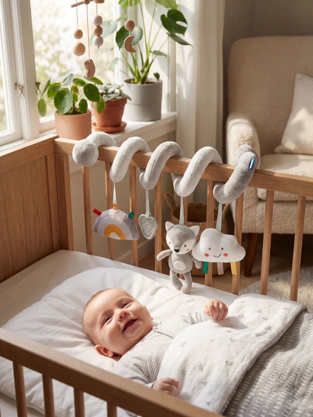 Nouveau-né souriant dans son lit observant la spirale d'éveil loup et le nuage suspendu.