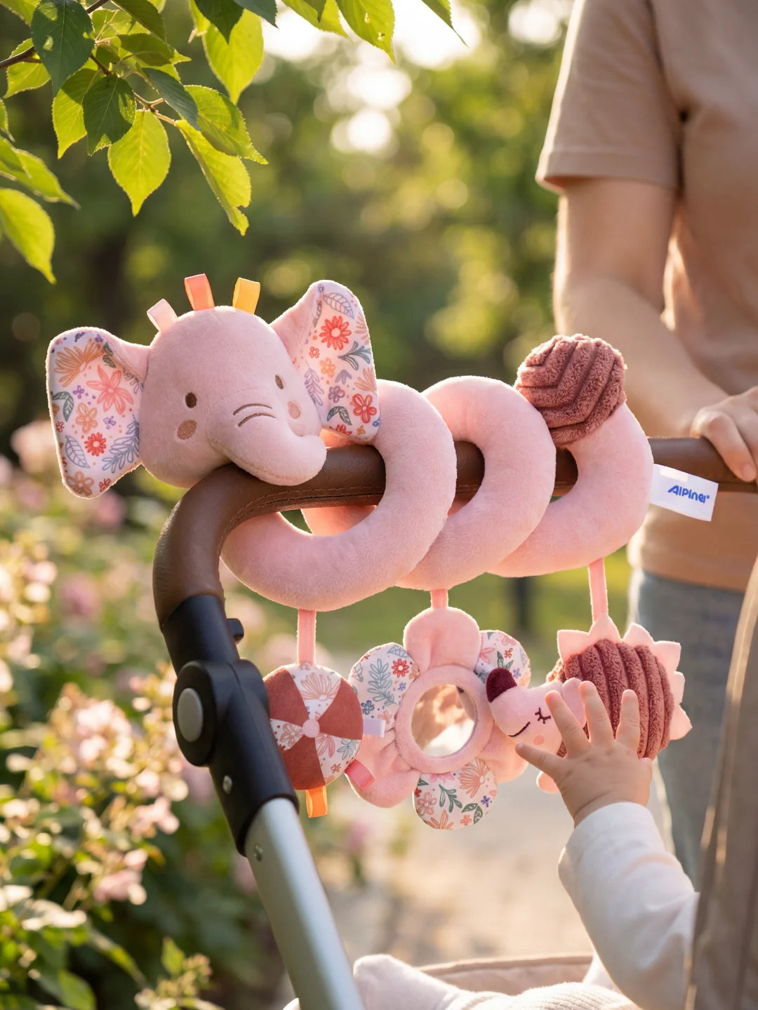 Spirale d'éveil éléphant rose avec hochet hérisson et miroir fleur lors d'une balade.