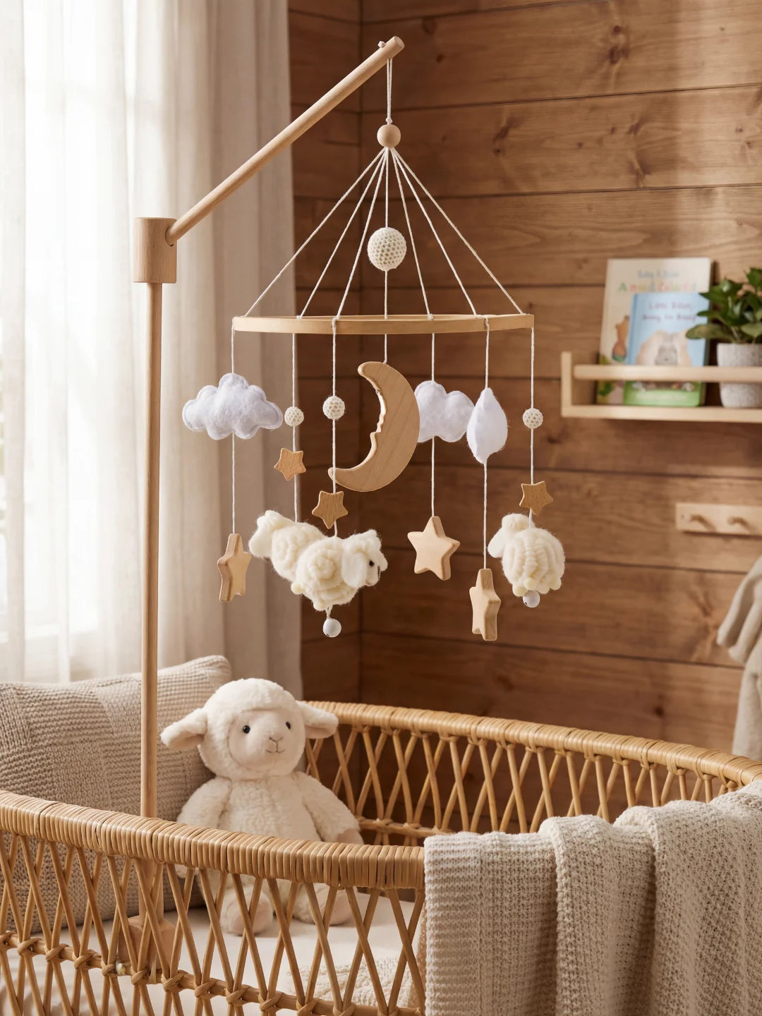 Mobile de lit mouton installé dans une chambre chaleureuse avec mur en bois et berceau en rotin.