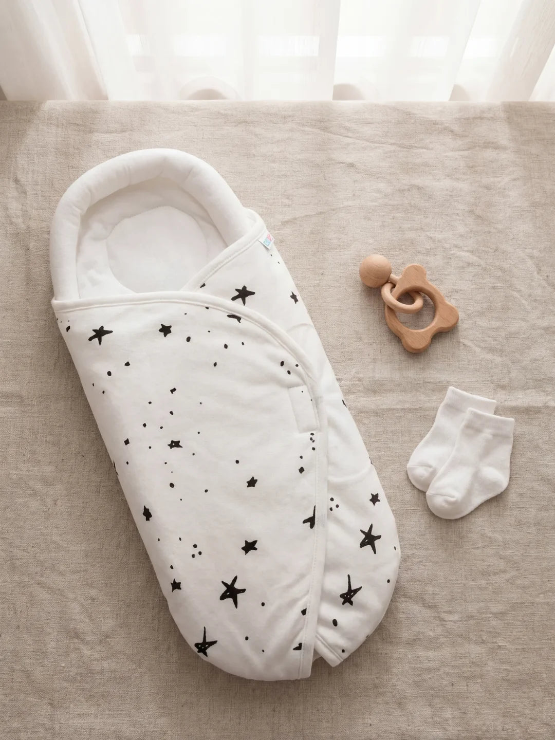 couverture d'emmaillotage bébé motif étoiles noires sur fond blanc