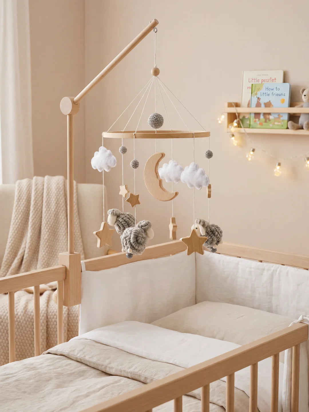 Ambiance de chambre bébé style Japandi avec mobile mouton gris, berceau bois et guirlande lumineuse.