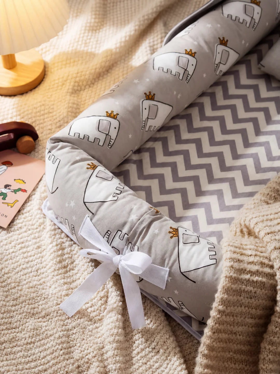 Détail du boudin rembourré du réducteur de lit bébé gris avec motif éléphants et couronnes