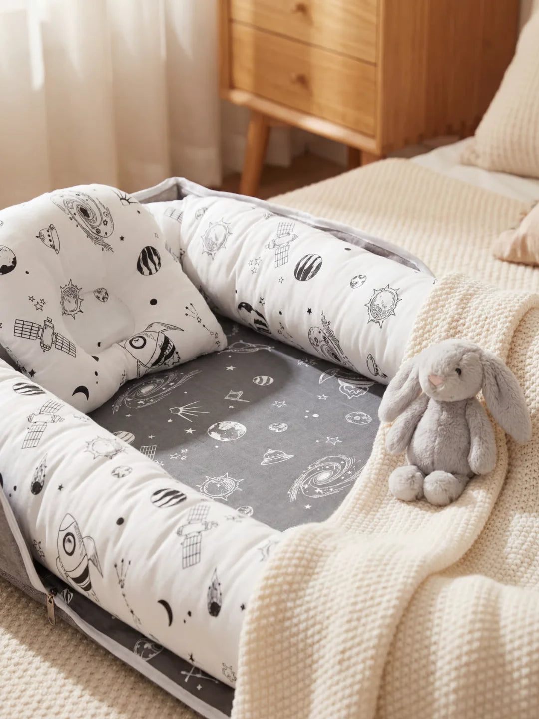 Détail du coussin anti tête plate du réducteur de lit bébé motif espace avec fusées et planètes