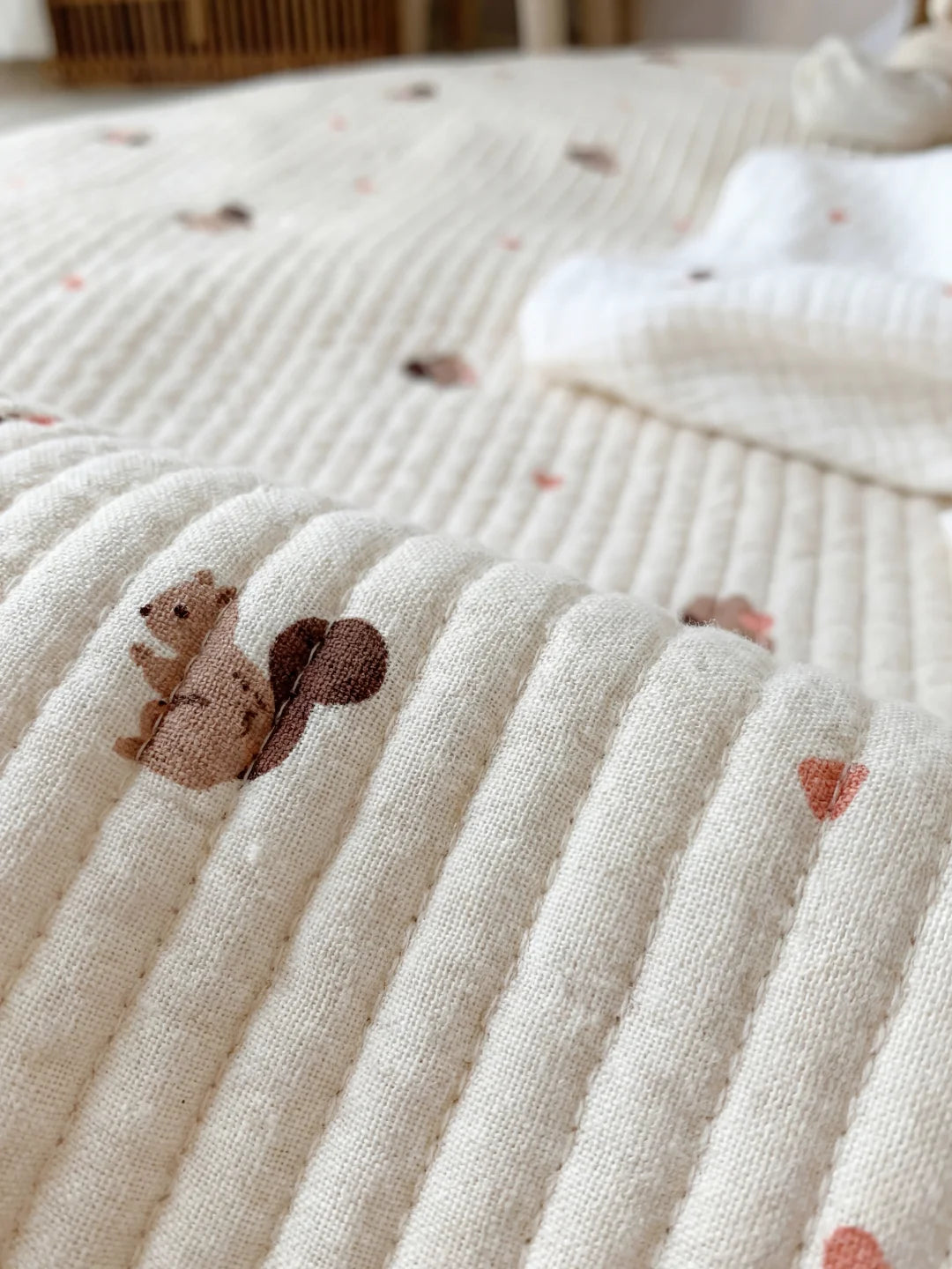 Détail de haute qualité d'un motif écureuil imprimé sur un tapis d'éveil pour bébé en coton.
