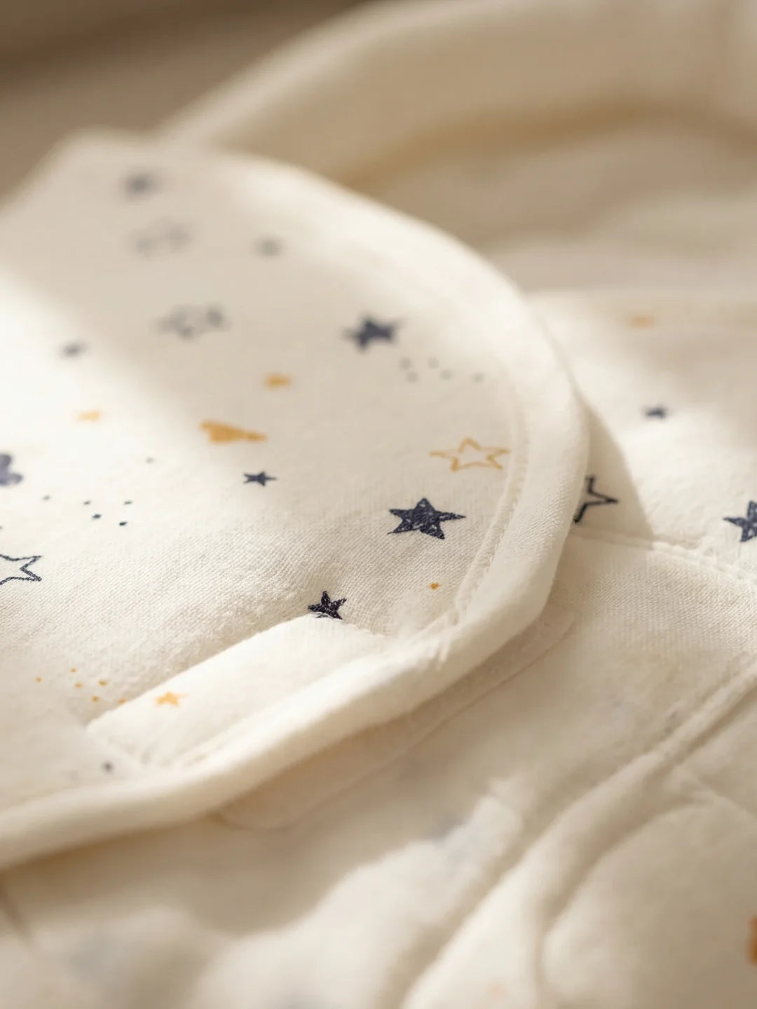 détail du tissu couverture emmaillotage motif étoiles et lune bleu doré
