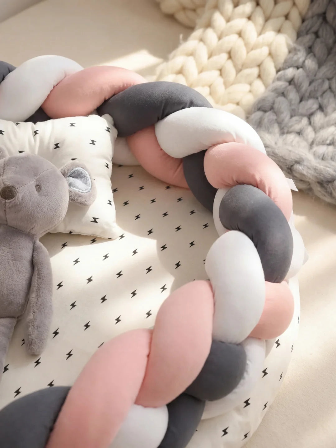 Détail de la tresse rose anthracite et blanche d'un réducteur de lit bébé