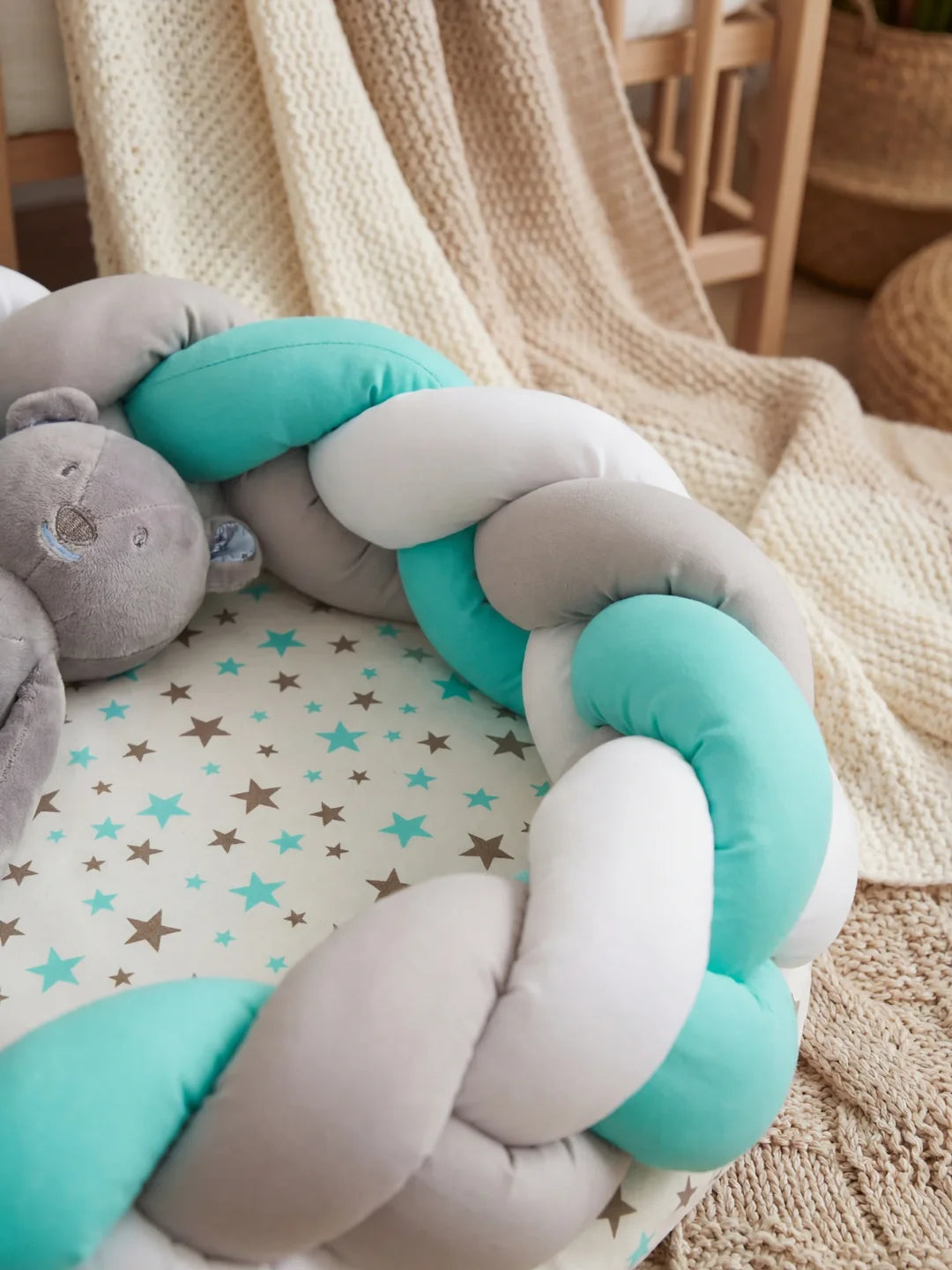 Détail de la tresse vert menthe gris et blanche d'un réducteur de lit bébé