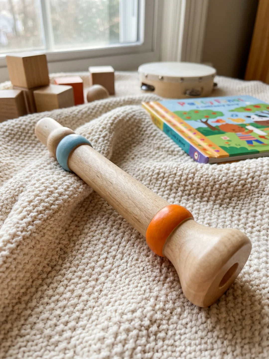 Flûte à bec en bois naturel avec anneaux de couleurs pour débuter la musique.