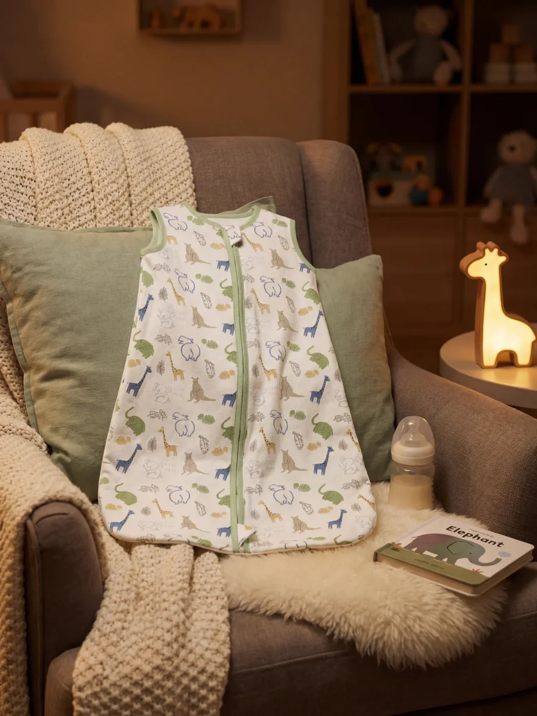 Gigoteuse bébé motif safari animaux posée sur fauteuil avec veilleuse girafe