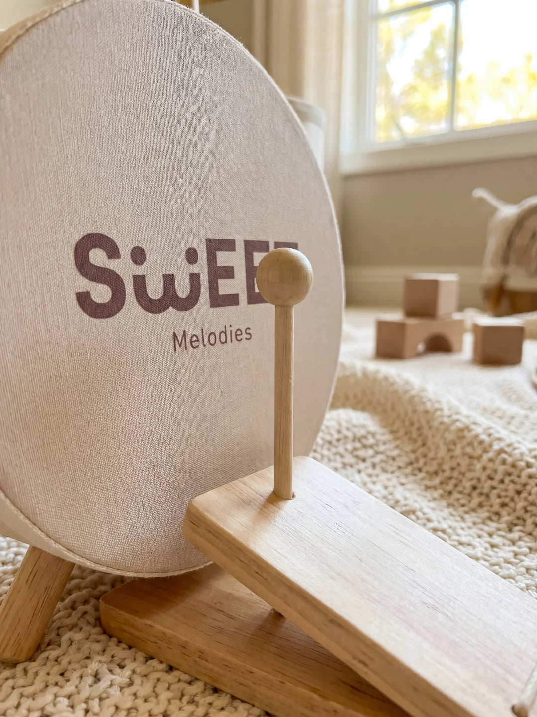 Détail du tambour de sol en tissu avec l'inscription 'Sweet Melodies' et sa pédale de grosse caisse en bois.