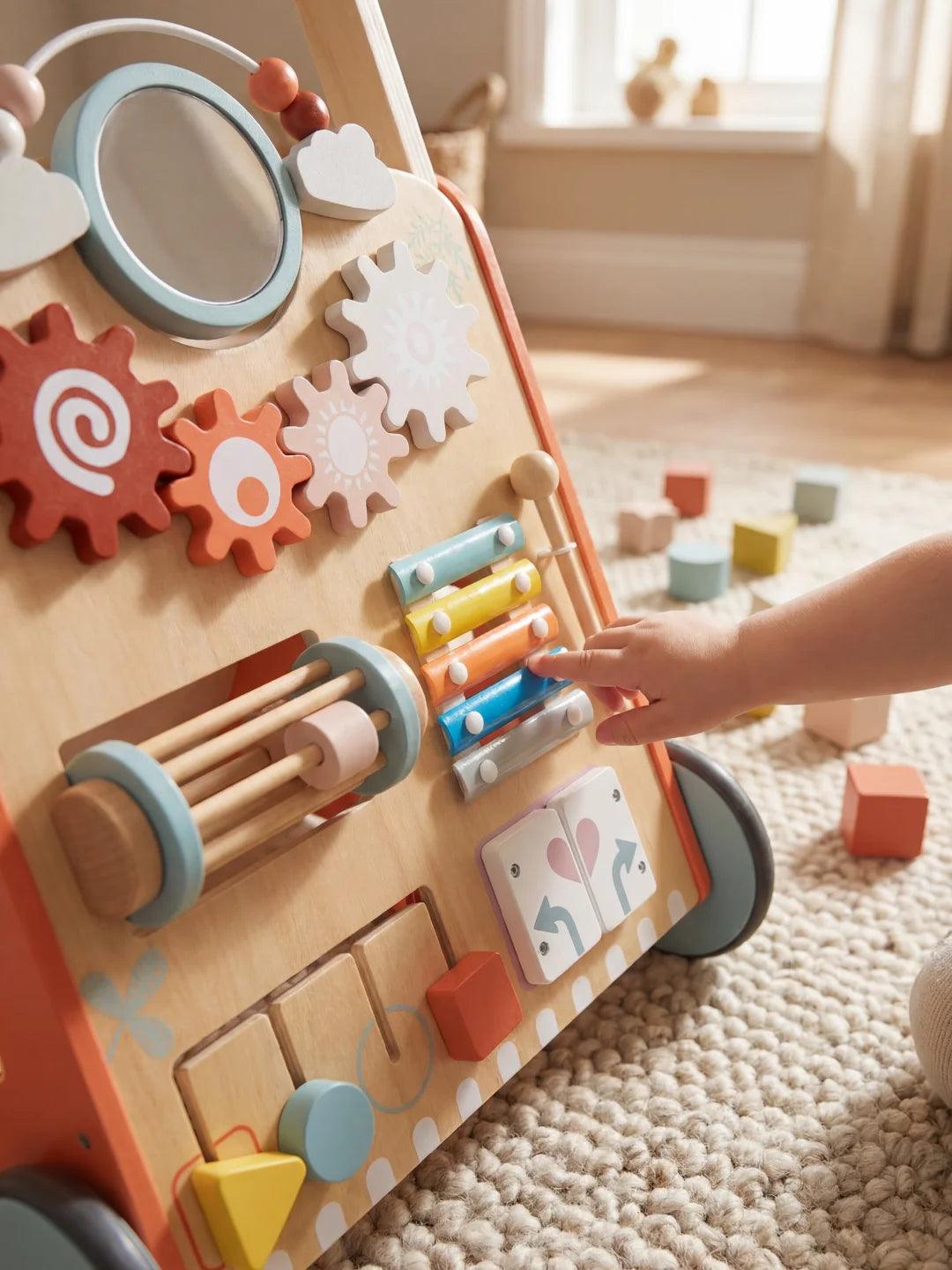 Enfant utilisant le xylophone intégré sur la face avant du chariot de marche Le P'tit Aventurier.