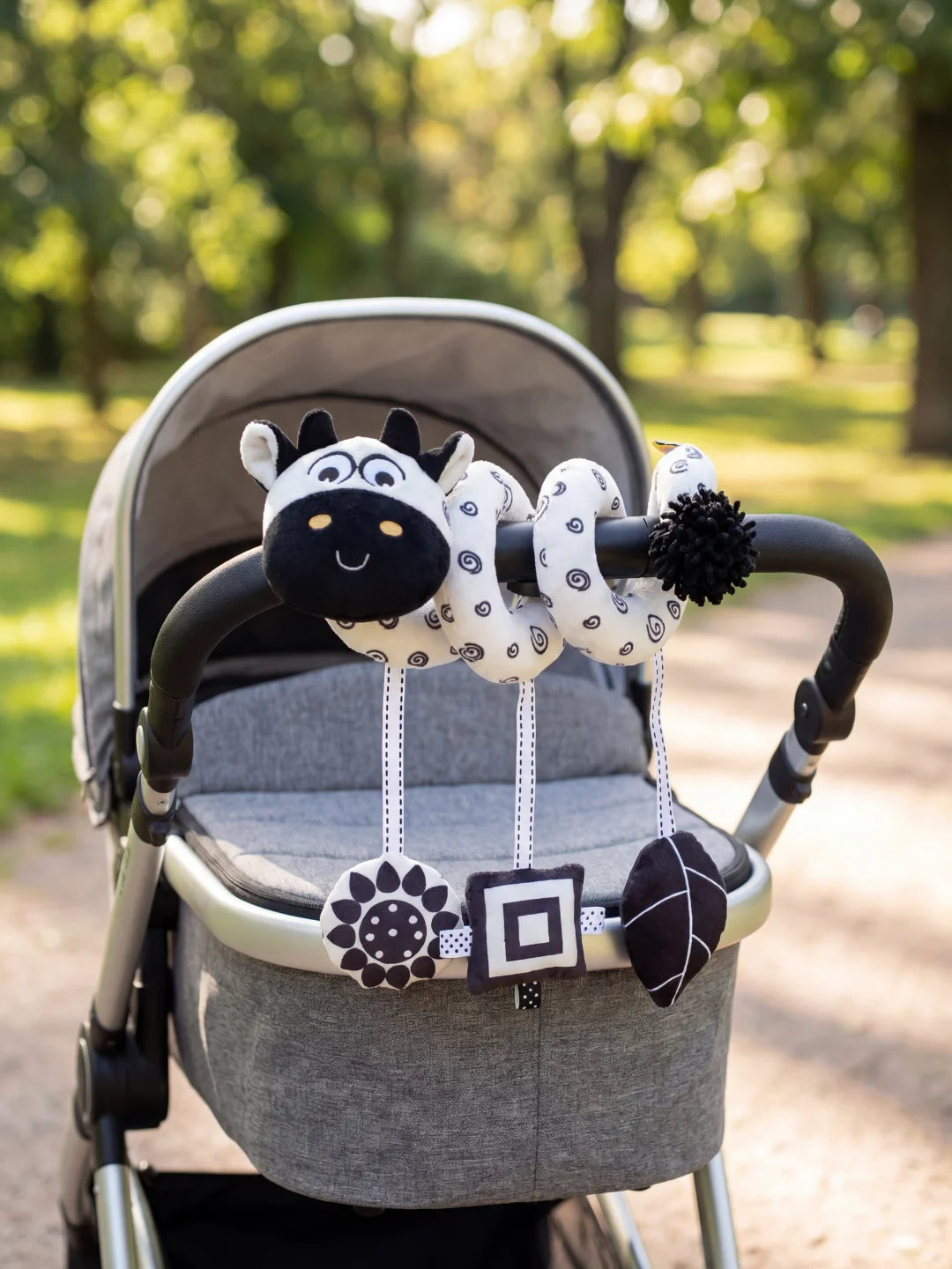 Jouet de poussette spirale noir et blanc avec hochets géométriques pour stimuler la vue de bébé.