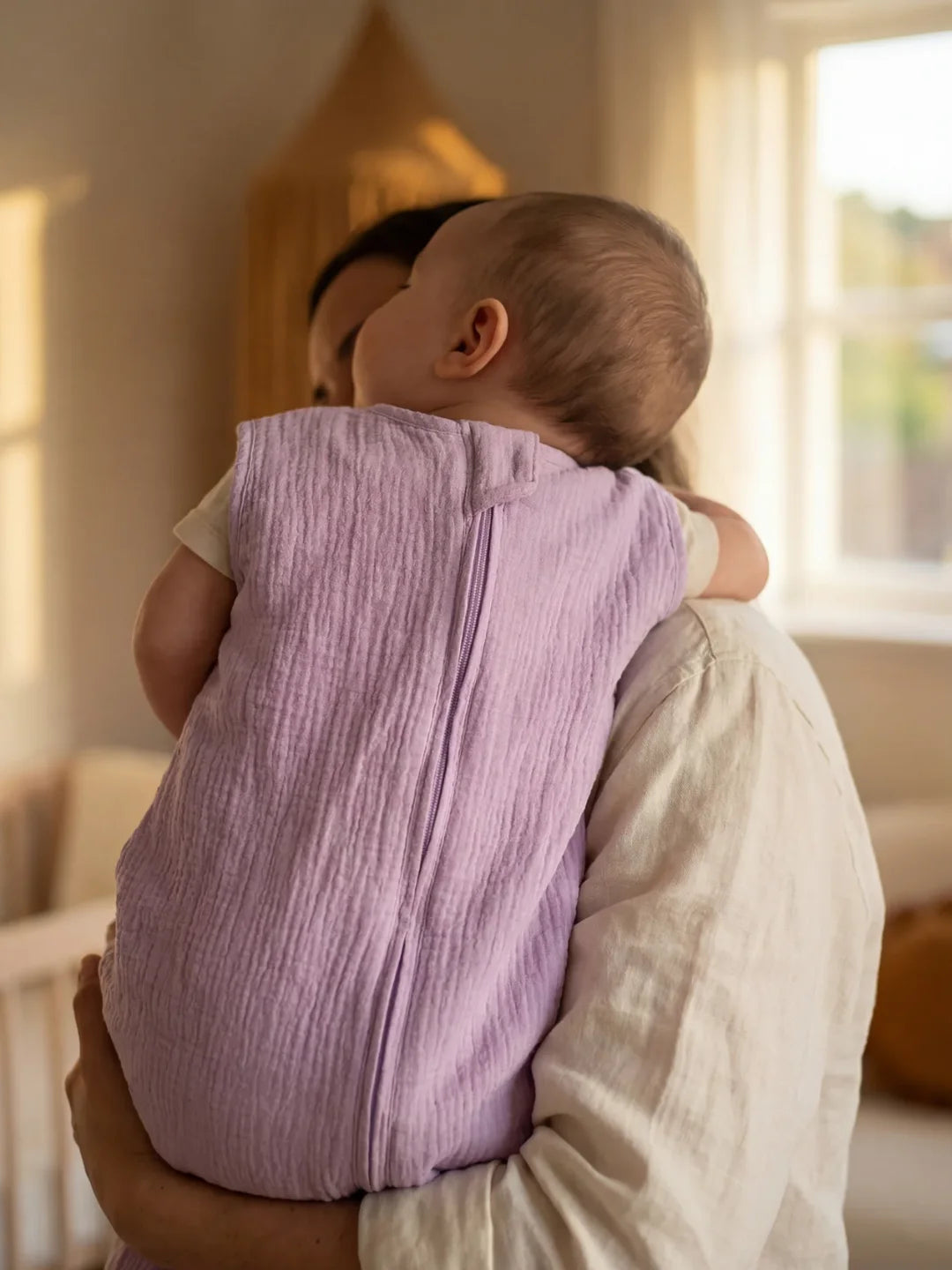 Maman portant bébé endormi dans sa gigoteuse gaze de coton lavande dans chambre