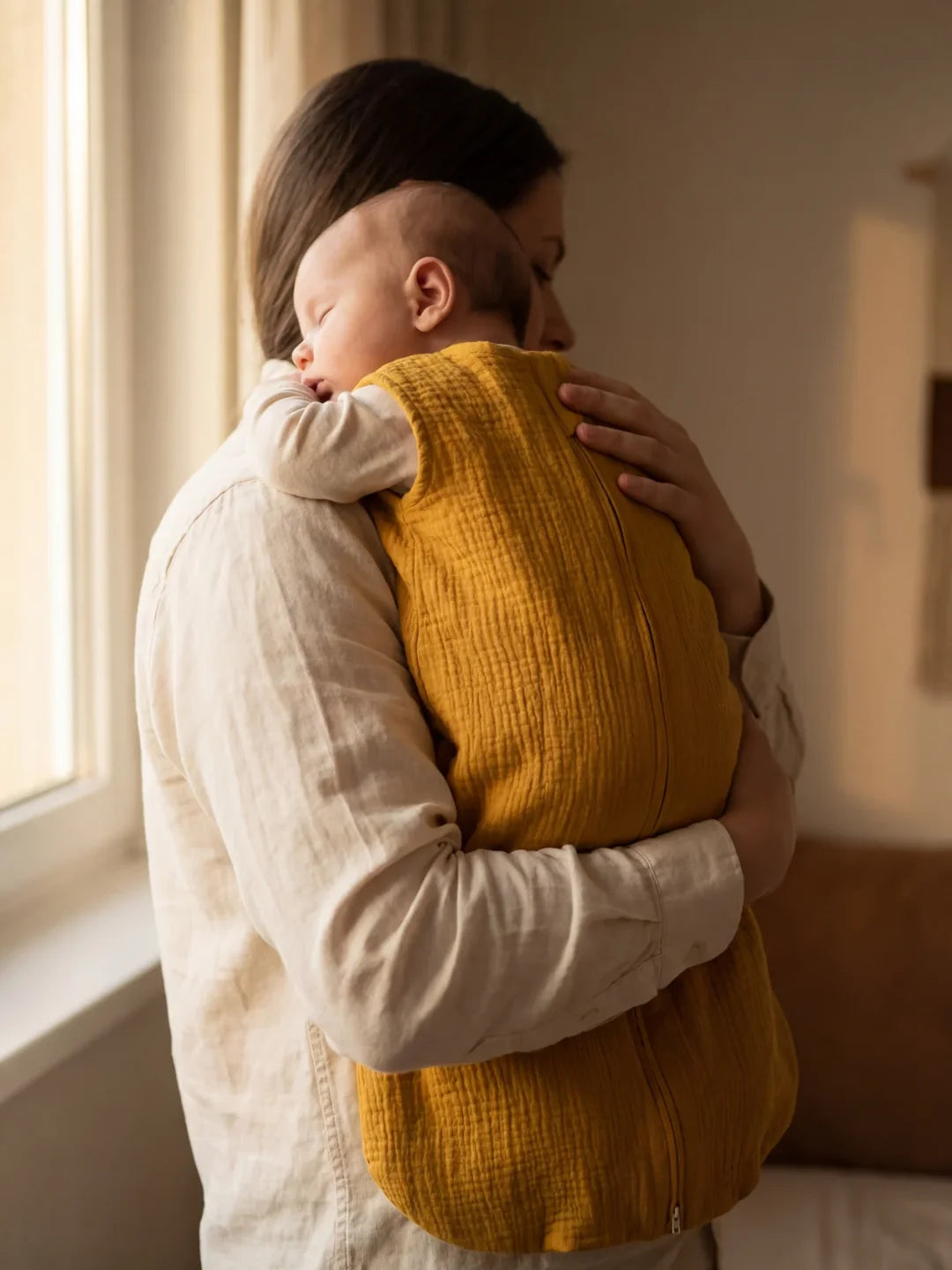 Bébé endormi dans sa gigoteuse gaze de coton moutarde avec doudou et tétine
