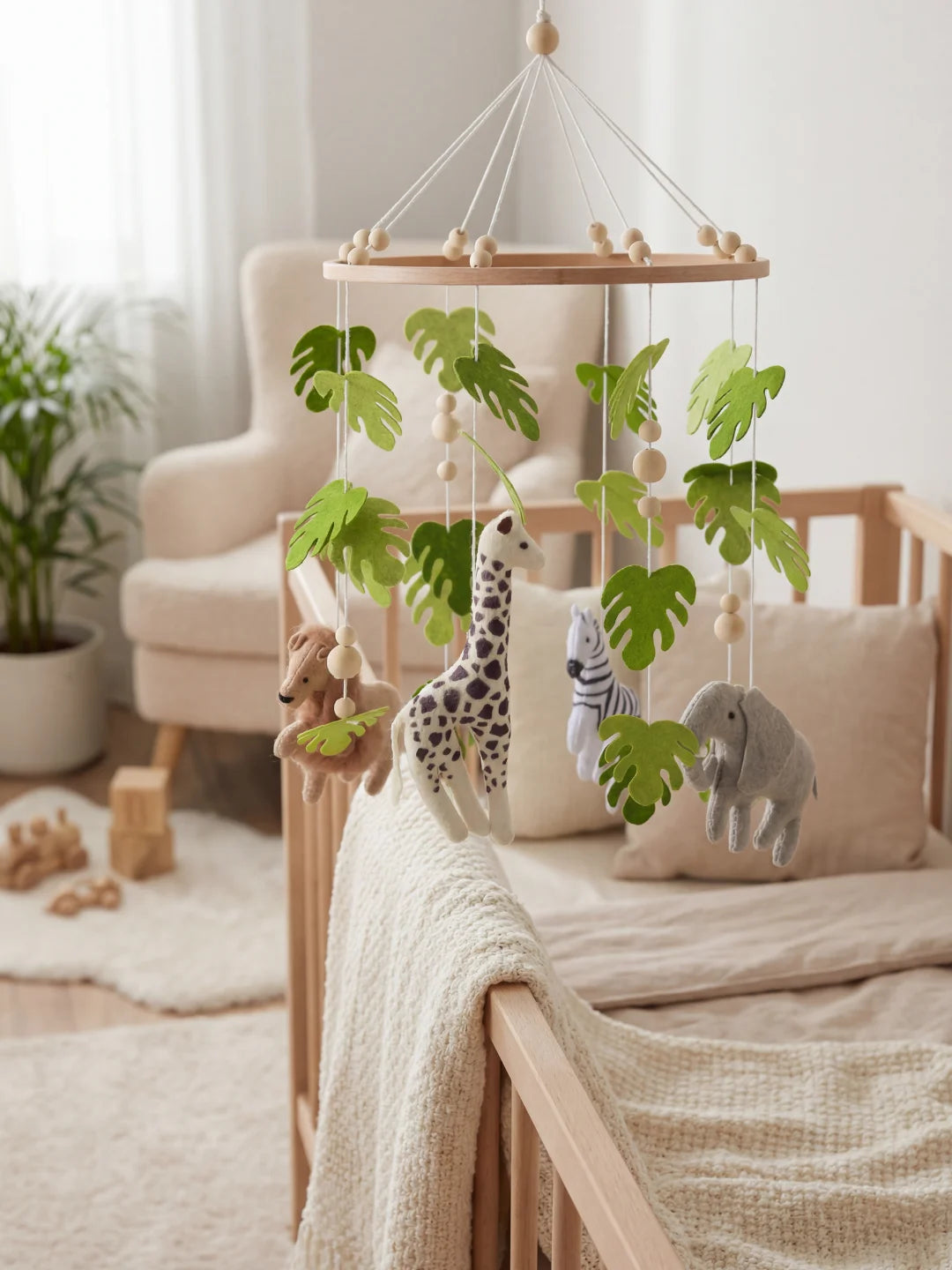 Vue d'ensemble d'un mobile pour nourrisson avec perles en bois et feuilles tropicales.