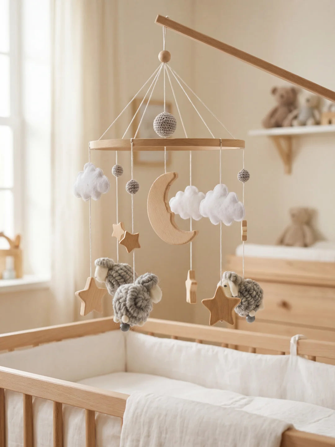 Mobile de lit bébé en bois avec suspensions moutons gris installé dans une chambre épurée.