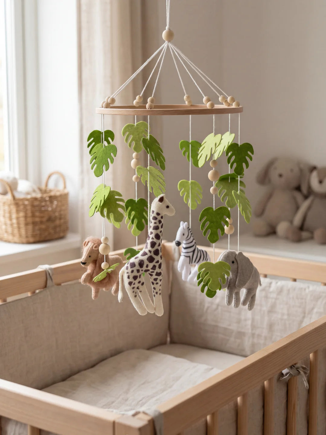 Mobile de lit pour enfant avec figurines de girafe et lion entourées de feuillage vert.