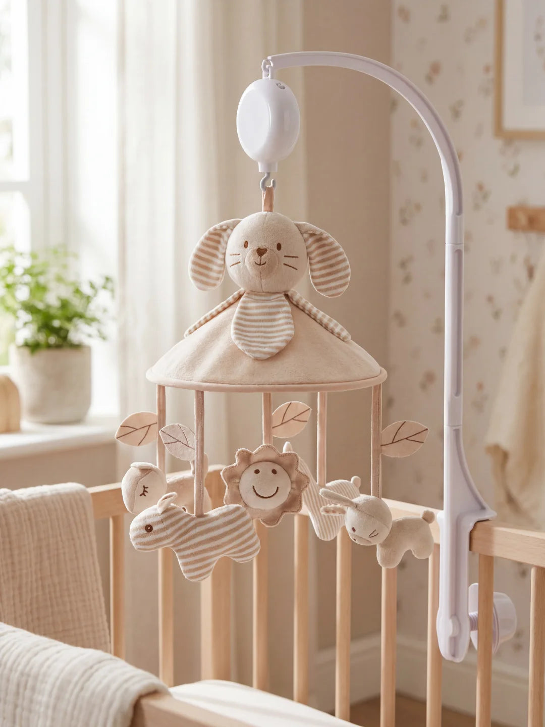 Mobile musical pour bébé avec peluche lapin beige, lion souriant et petit éléphant en tissu rayé.