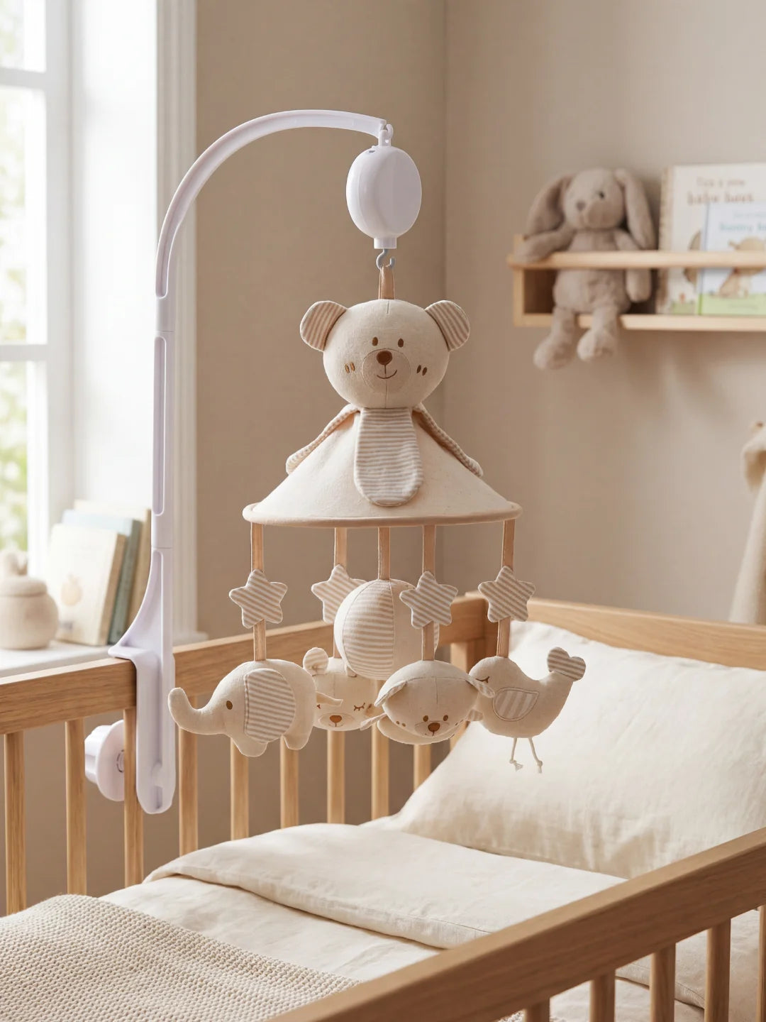 Mobile musical pour bébé avec une grande peluche ours beige et des suspensions étoiles et animaux.