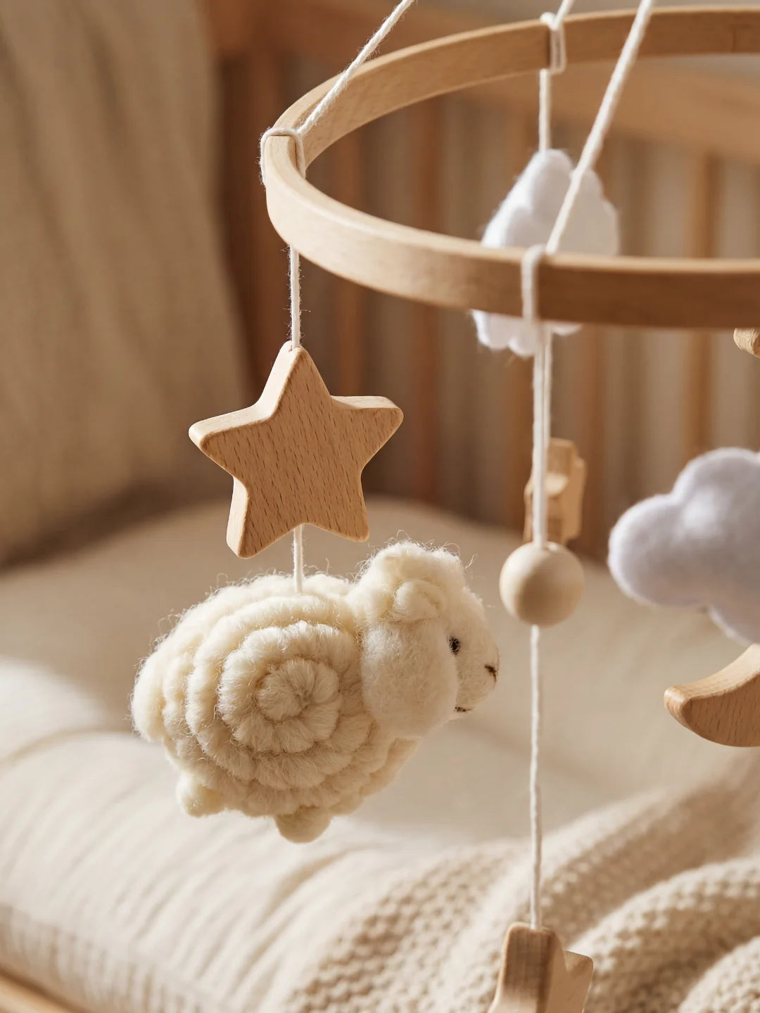 Détail des matières : mouton en laine texturée et étoile en bois lisse pour mobile d'éveil.
