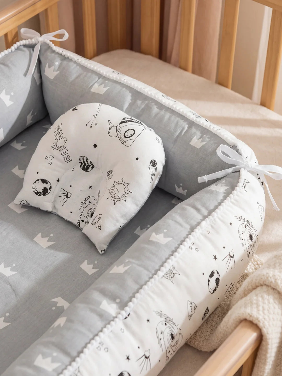 Petit oreiller pour bébé avec motifs de planètes et fusées, conçu pour le maintien de la tête.