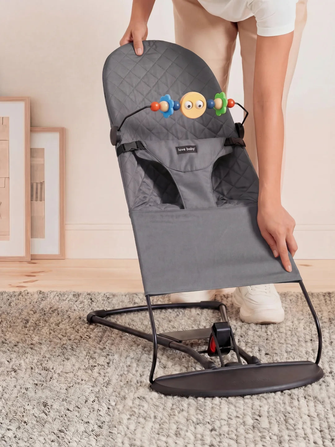 Démonstration de la légèreté et du pliage à plat du transat gris anthracite pour un rangement facile.