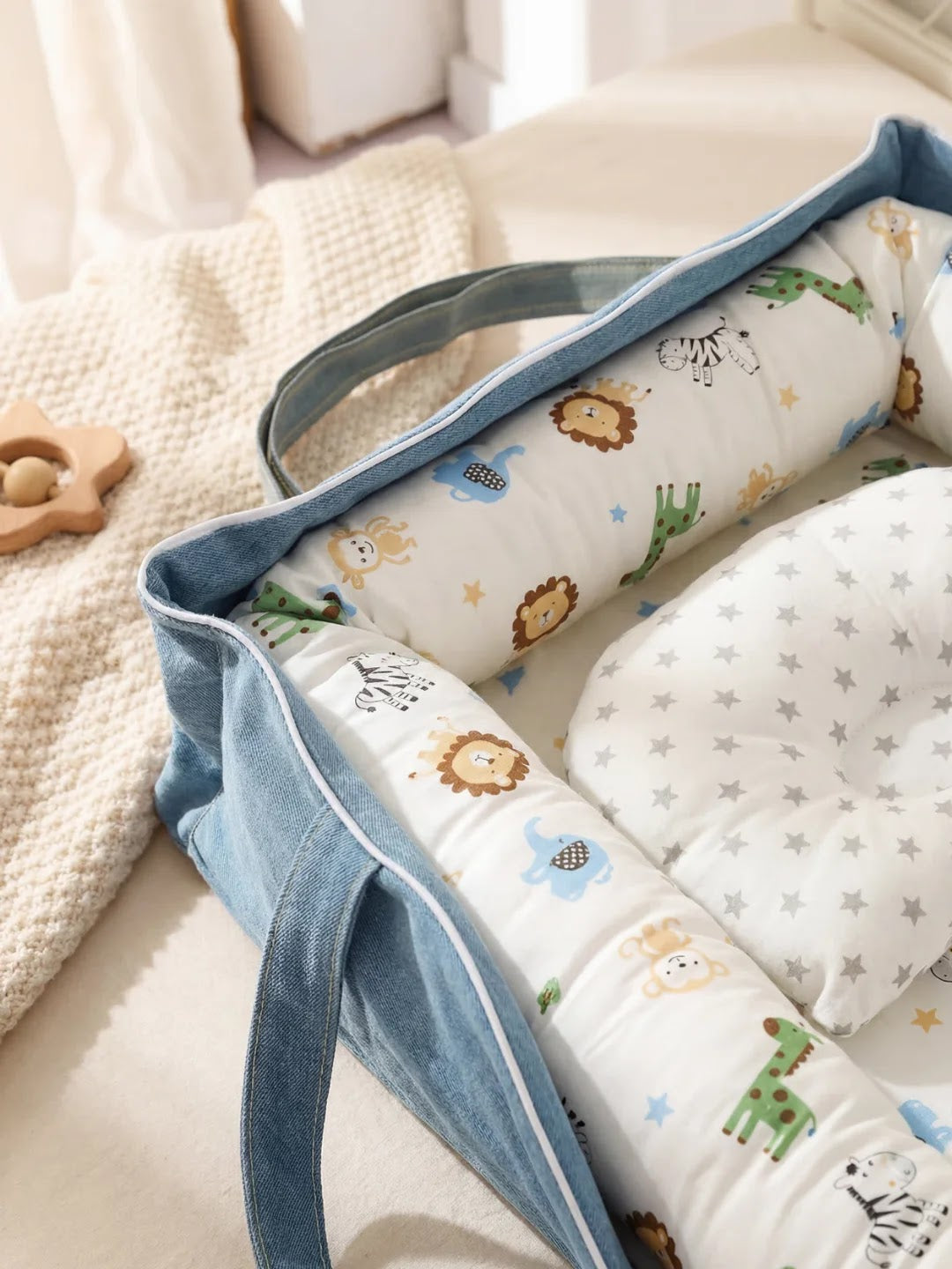 Réducteur de lit avec motifs d'animaux, vu de dessus, dans un sac bleu sur un lit.
