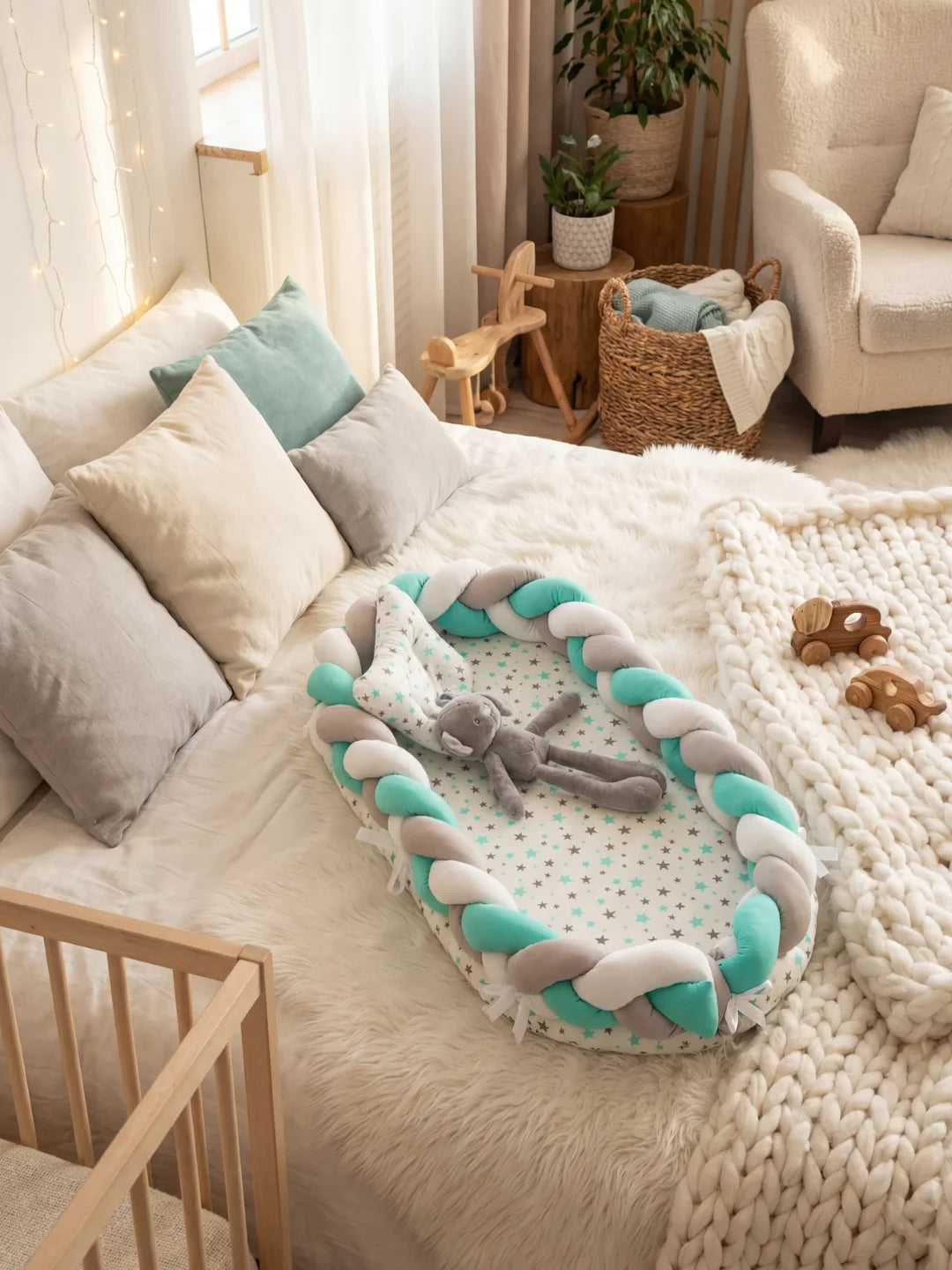 Réducteur de lit tressé vert menthe gris et blanc avec peluche sur lit