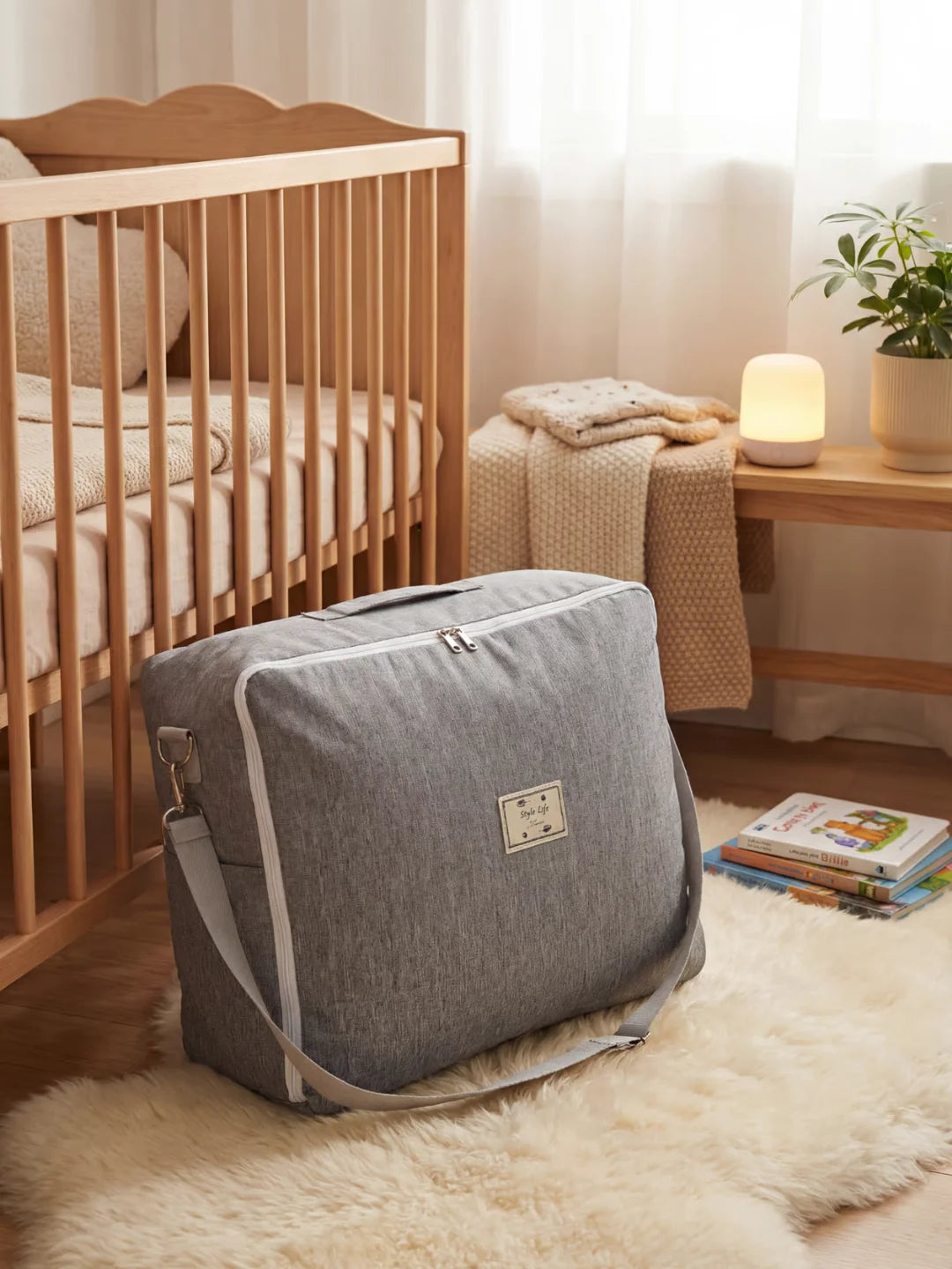 Sac de transport gris avec bandoulière pour réducteur de lit bébé dans une chambre nursery