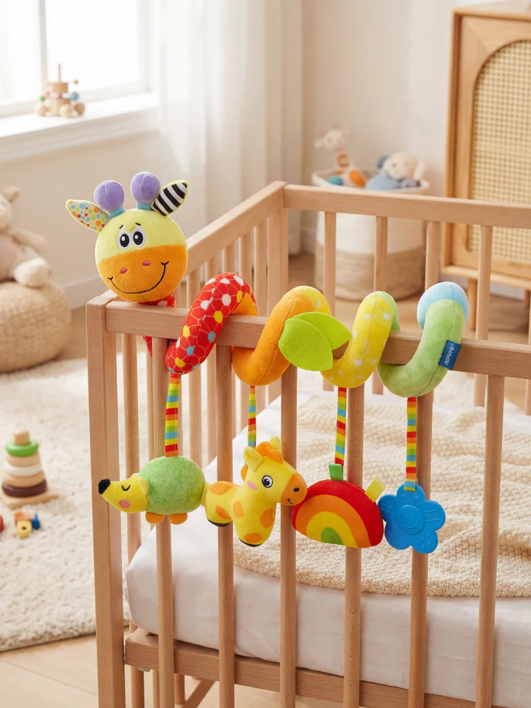 Spirale d'activité colorée pour bébé avec tête de girafe, hochet suspendu et anneau de dentition bleu fixée sur une poussette