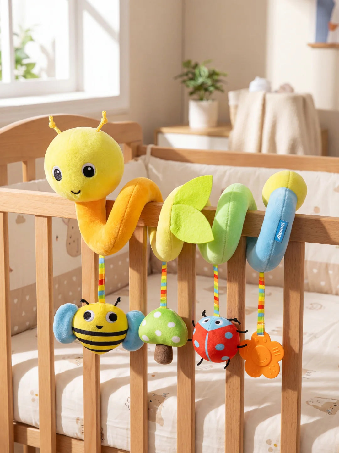 Spirale d'activité chenille fixée sur un berceau avec anneau de dentition fleur orange.