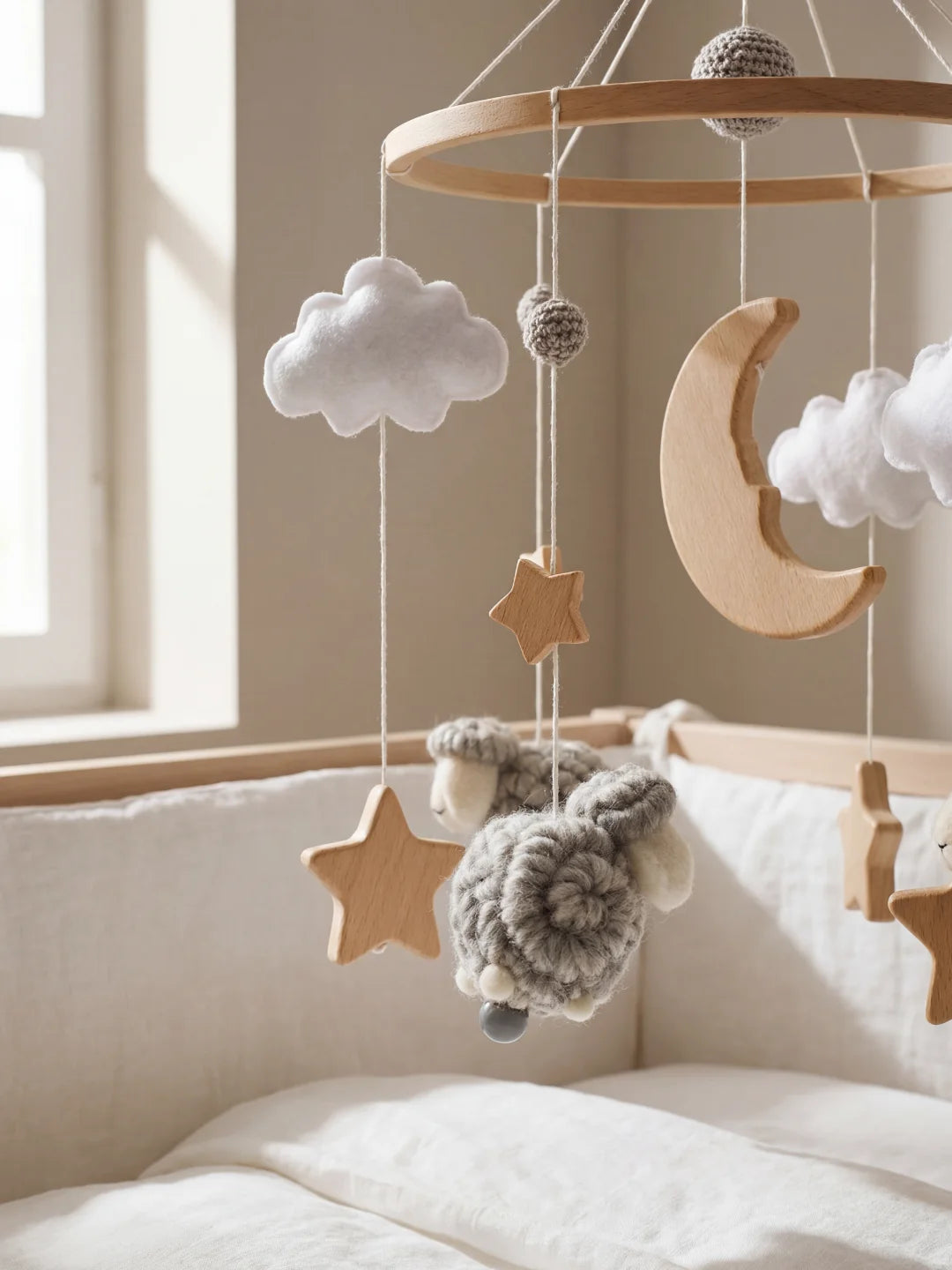 Détails des suspensions : lune en bois massif, nuage blanc en feutrine et mouton gris.