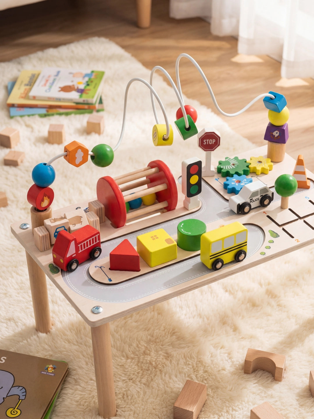 Table d'activité circuit routier avec véhicules en bois, jeu de motricité et blocs colorés, sur un tapis en peau.