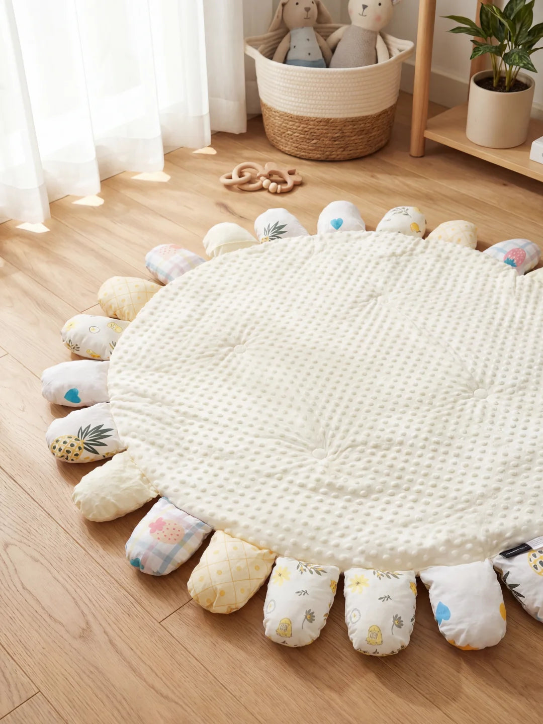 Tapis de sol sensoriel blanc entouré de pétales colorés aux imprimés tropicaux et doux.