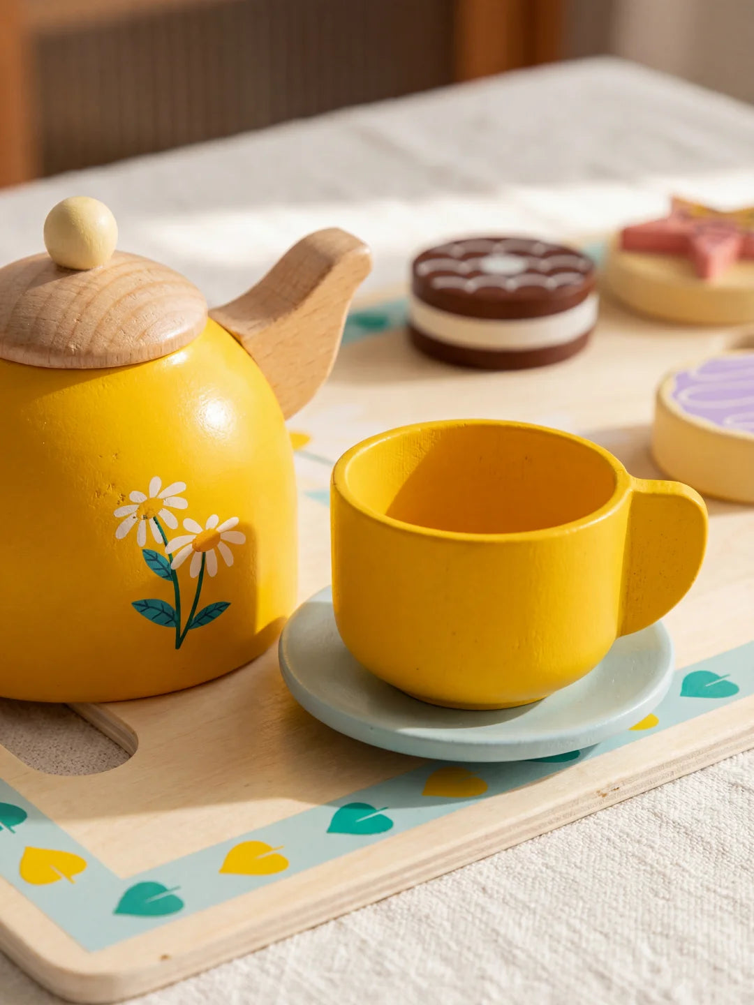 Théière en bois jaune avec motifs de fleurs blanches, faisant partie d'un set d'éveil Montessori