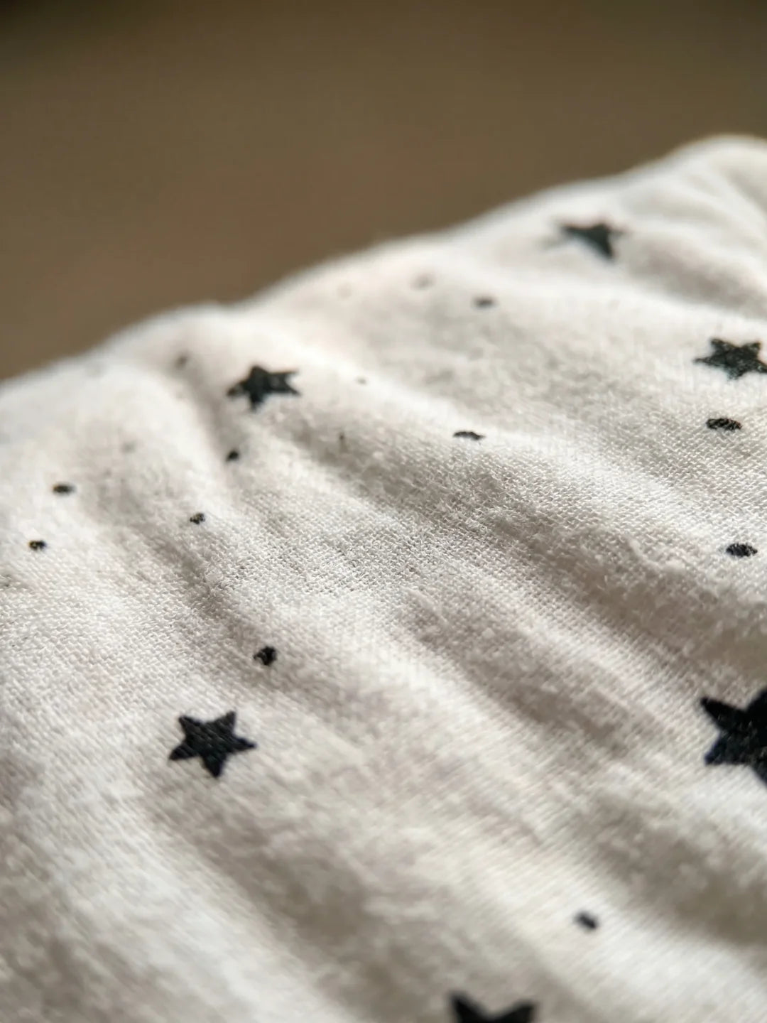 couverture d'emmaillotage bébé motif étoiles noires vue à plat avec accessoires