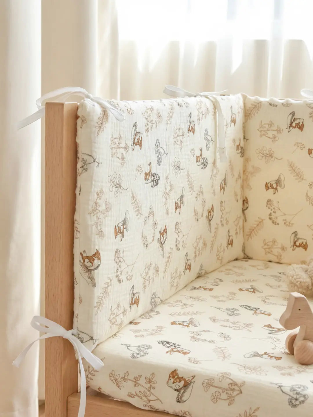 Tour de Lit Matelassé avec motifs d'animaux installé dans un berceau