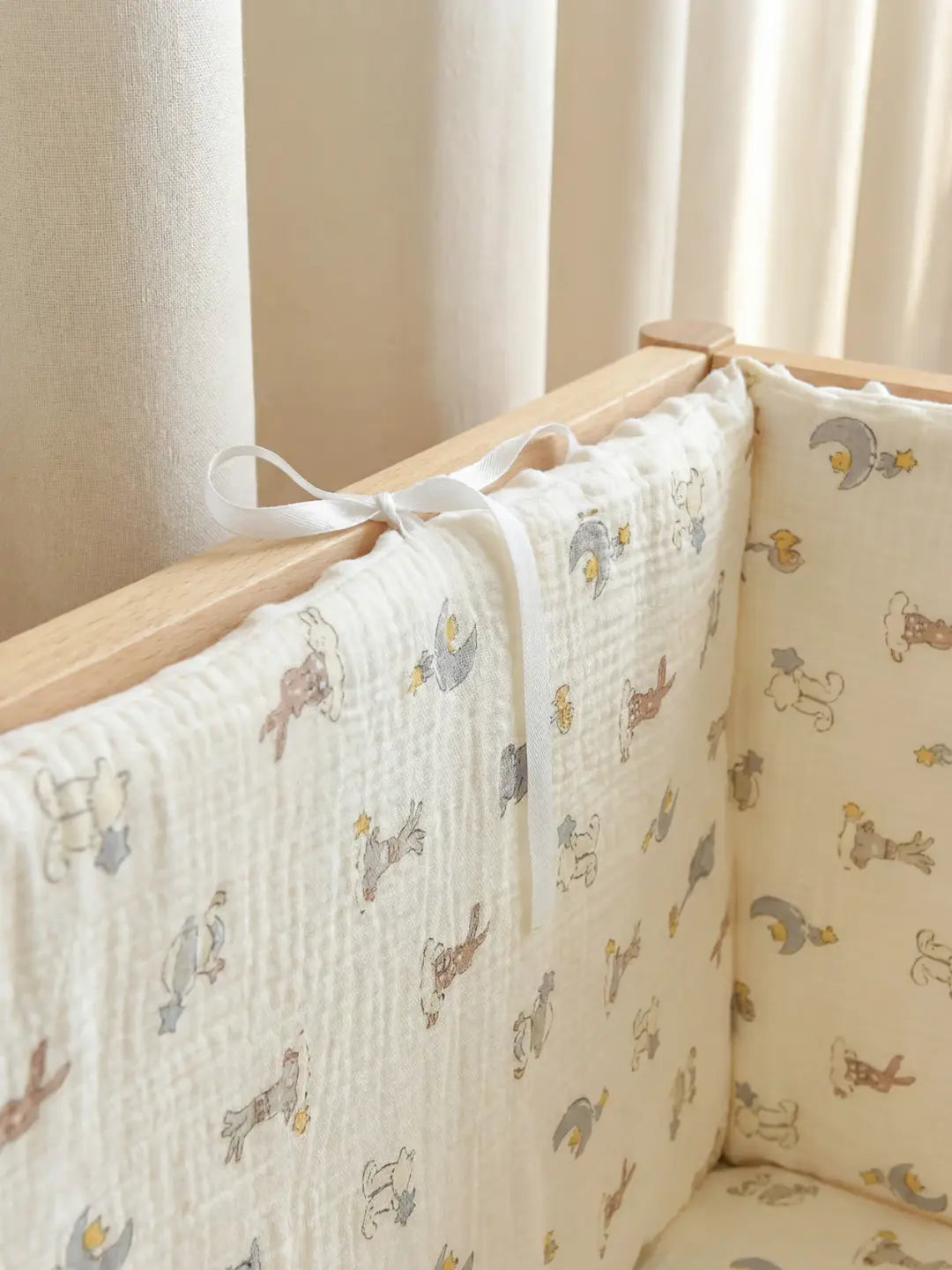 Tour de Lit Matelassé avec motif d'animaux installée dans un berceau