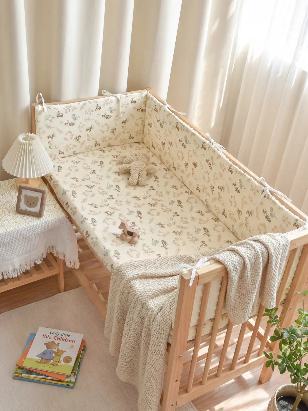 Tour de Lit Matelassé avec motifs imprimés installé dans un berceau en bois