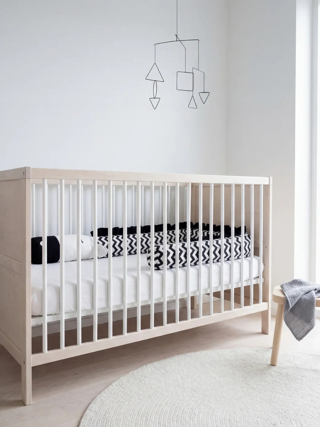 Tour de lit traversin bébé noir et blanc chevron dans lit à barreaux clair