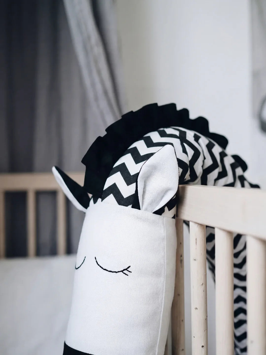 Détail tête animale du tour de lit traversin bébé chevron noir et blanc