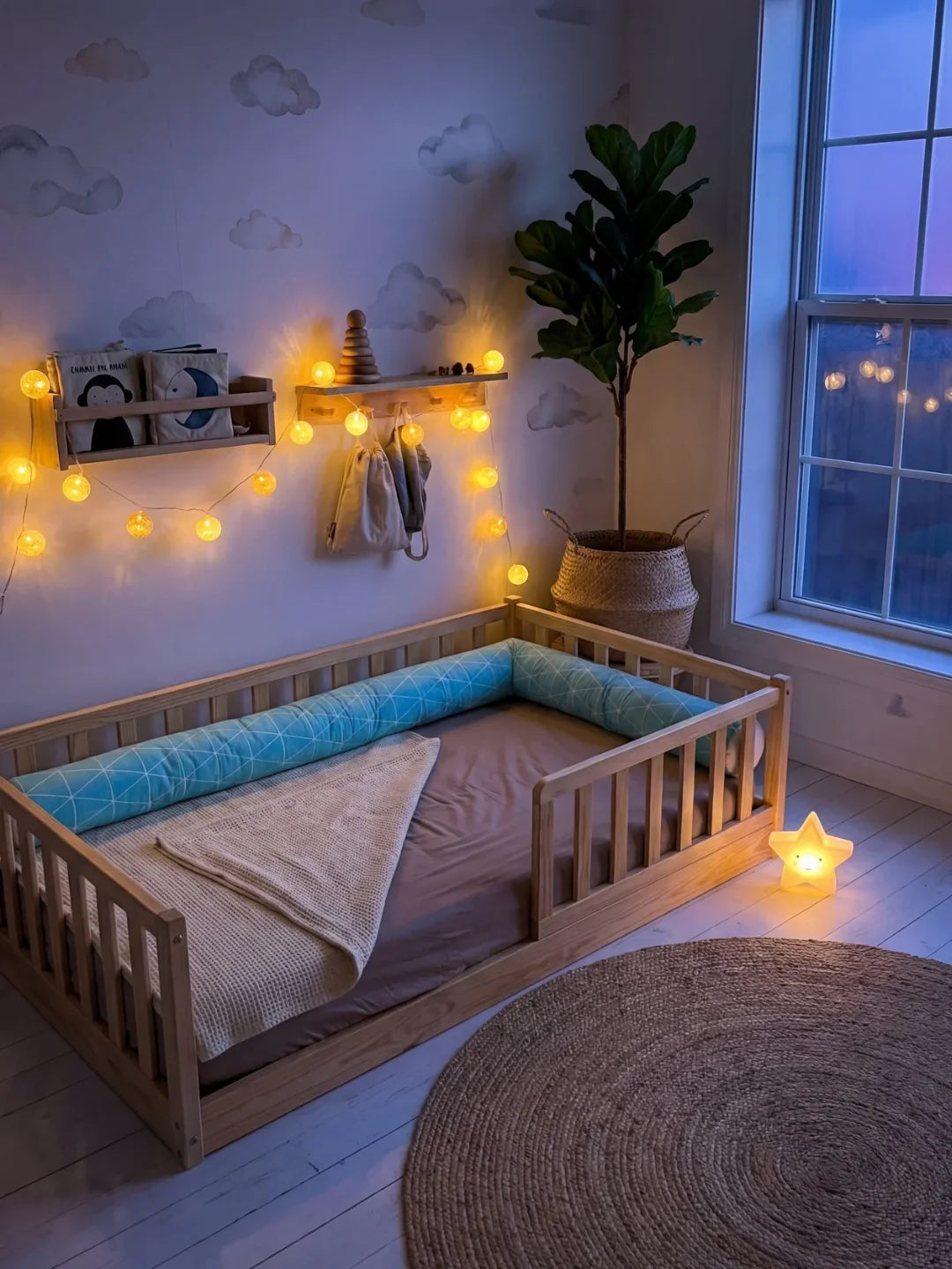Tour de lit traversin géométrique bleu dans lit Montessori avec guirlande lumineuse