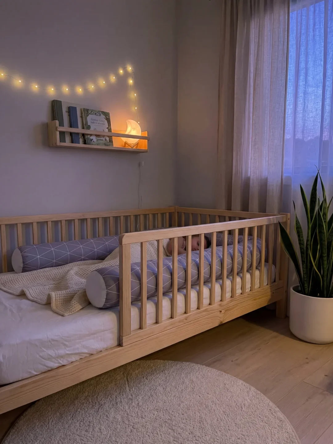 Tour de lit traversin géométrique gris installé dans lit Montessori en bois