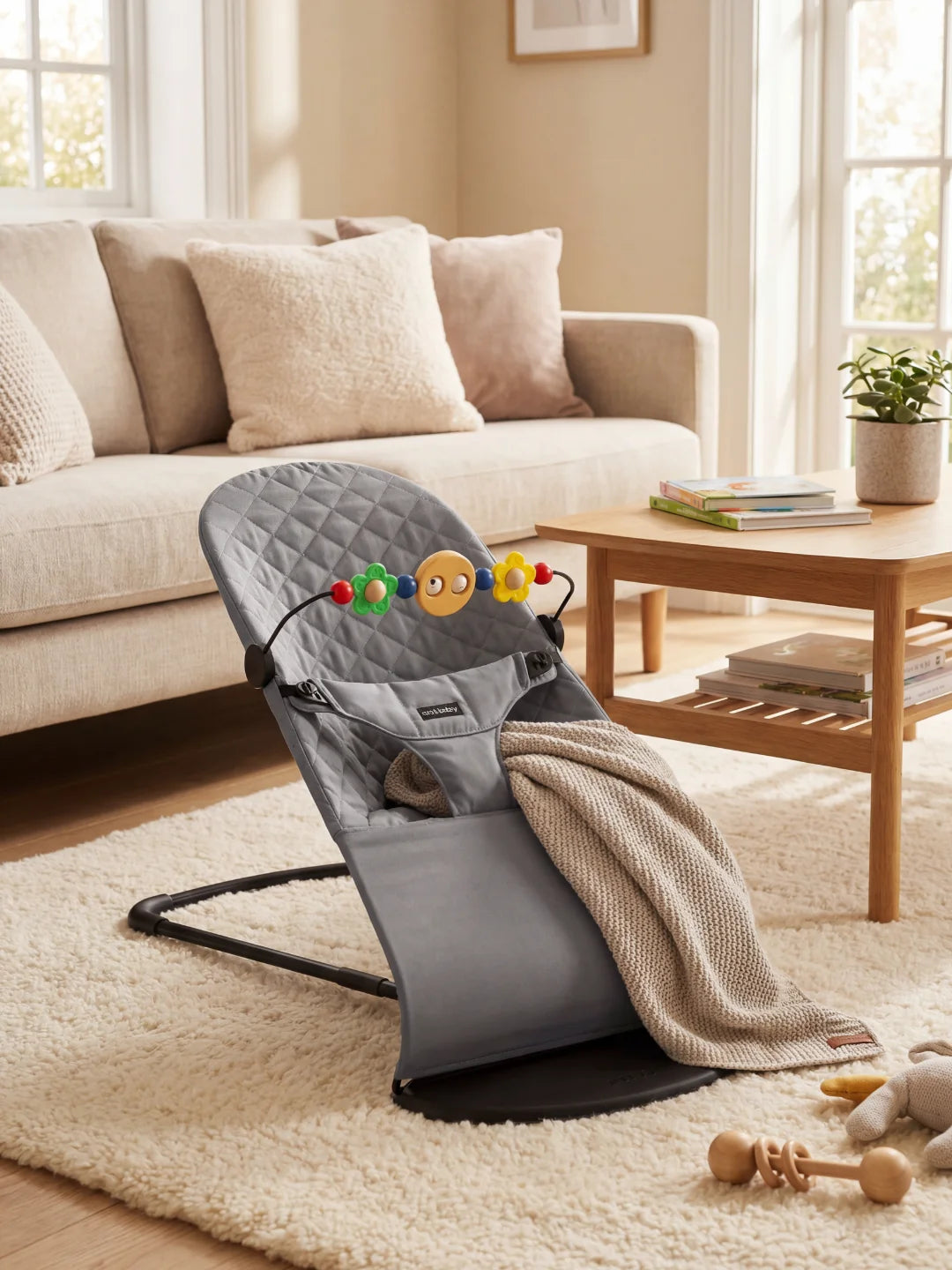 Transat pour nouveau-né gris anthracite avec arche d'éveil, s'intégrant parfaitement dans une décoration moderne.